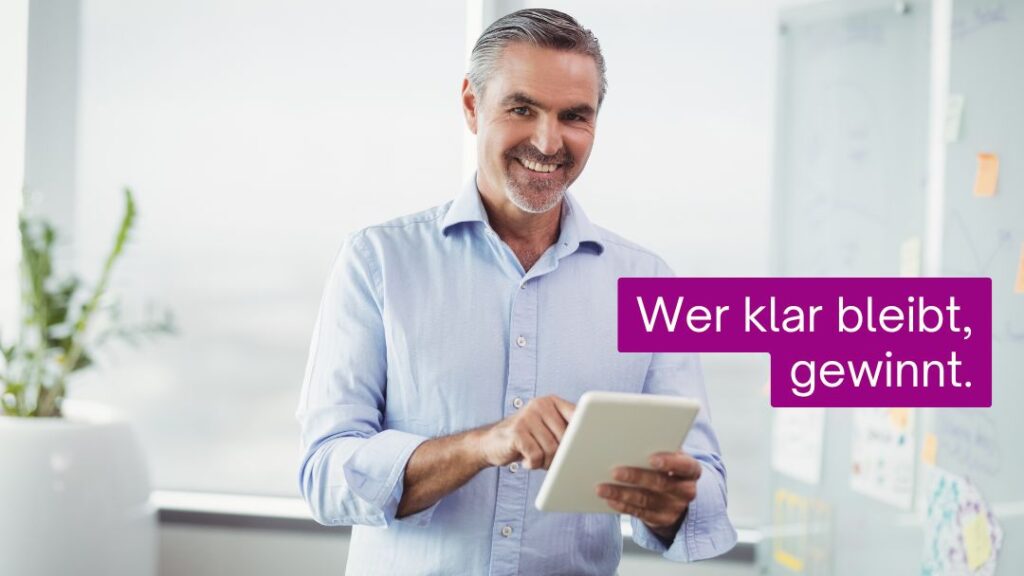 Mann in blauem Hemd mit Tablet, lächelt